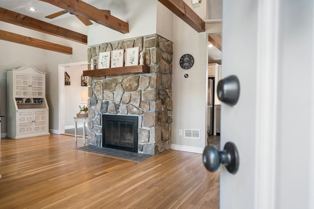 18 Corcoran Road Billerica, MA 01821 - Photo 7 of 40 a bedroom with a fireplace and a chandelier