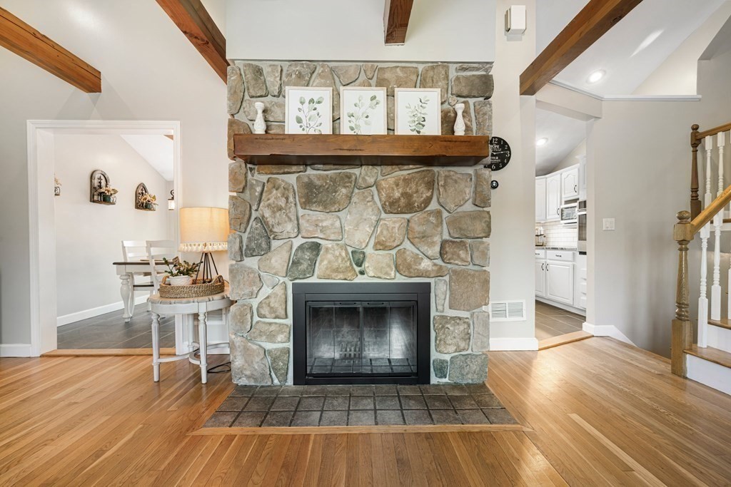 18 Corcoran Road Billerica, MA 01821 - Photo 8 of 40 a living room with a fireplace and a wooden floor