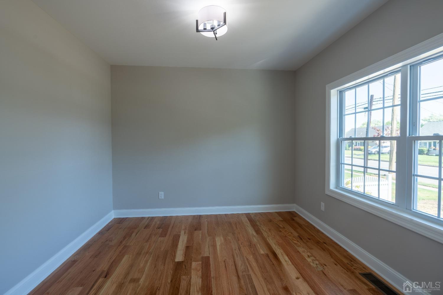 624 New Dover Road Colonia, NJ 07067 - Photo 11 of 29 wooden floor in an empty room with a window