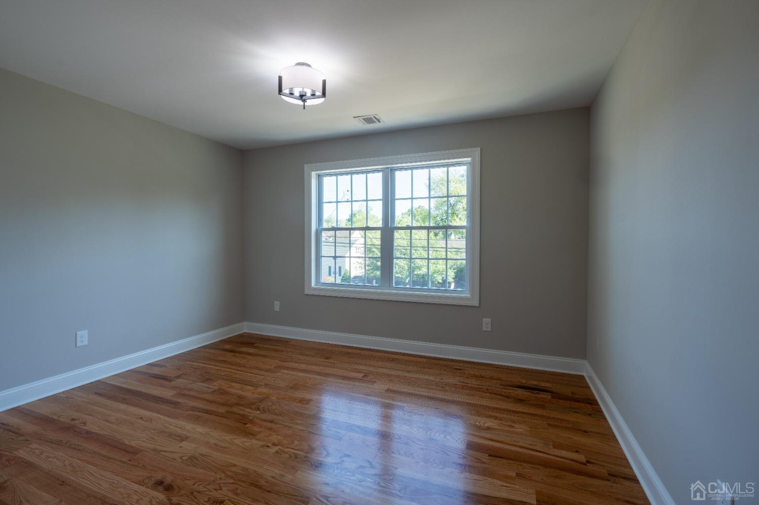 624 New Dover Road Colonia, NJ 07067 - Photo 15 of 29 an empty room with wooden floor and windows