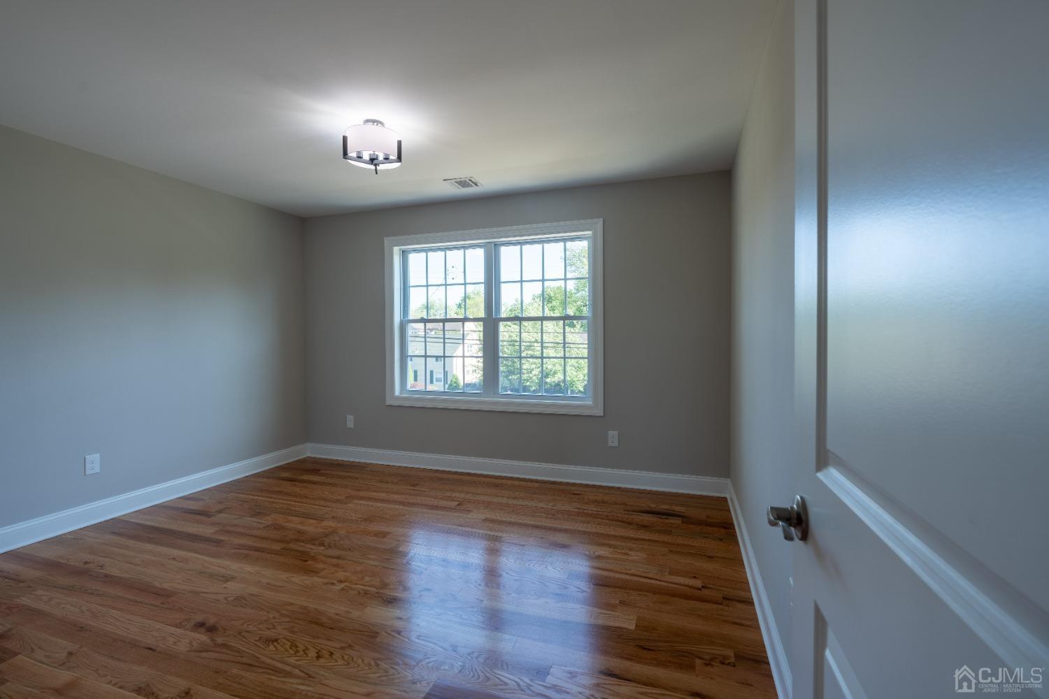 624 New Dover Road Colonia, NJ 07067 - Photo 16 of 29 wooden floor in an empty room with a window