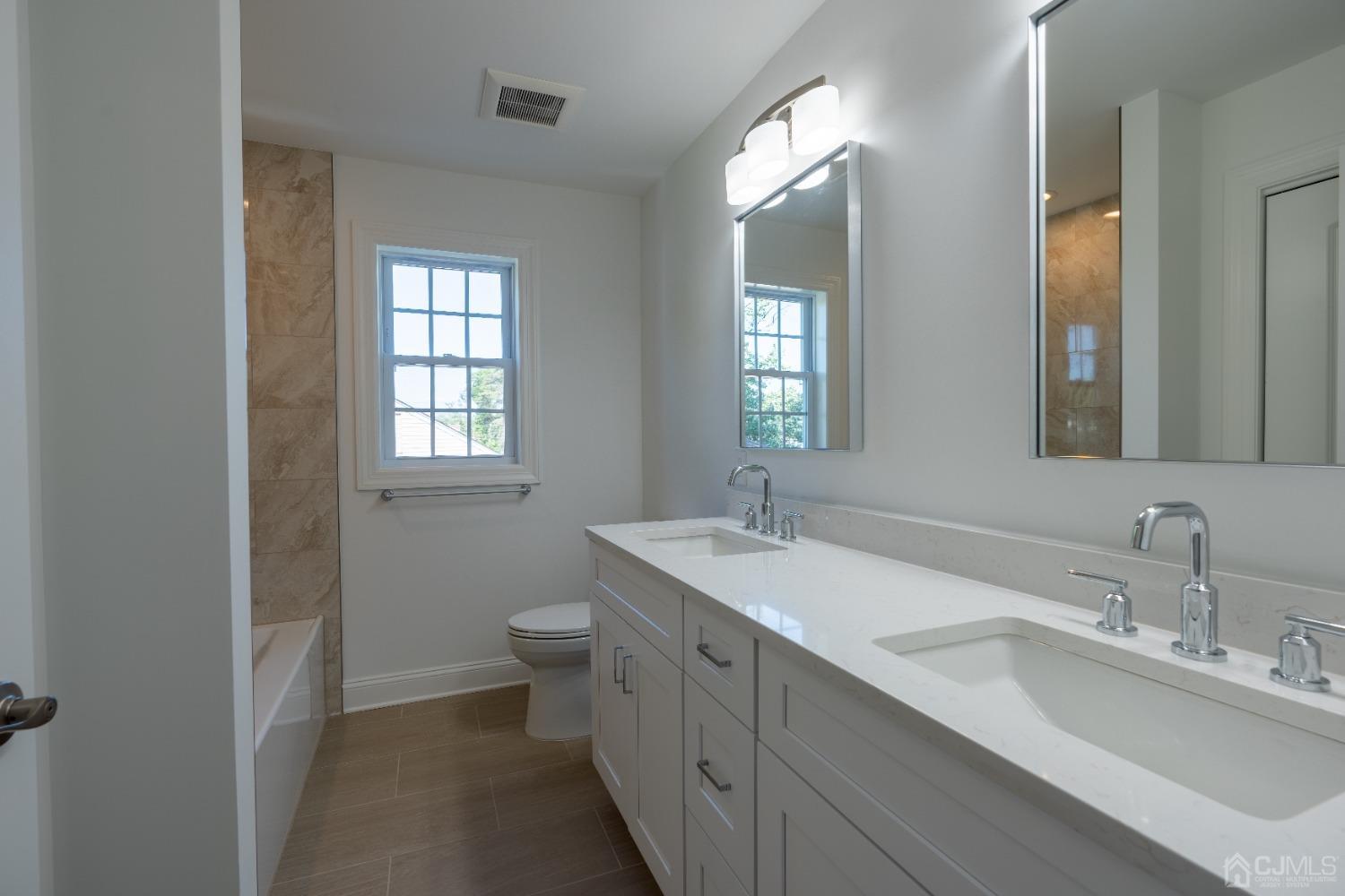 624 New Dover Road Colonia, NJ 07067 - Photo 17 of 29 a bathroom with 2 sink toilet and a mirror