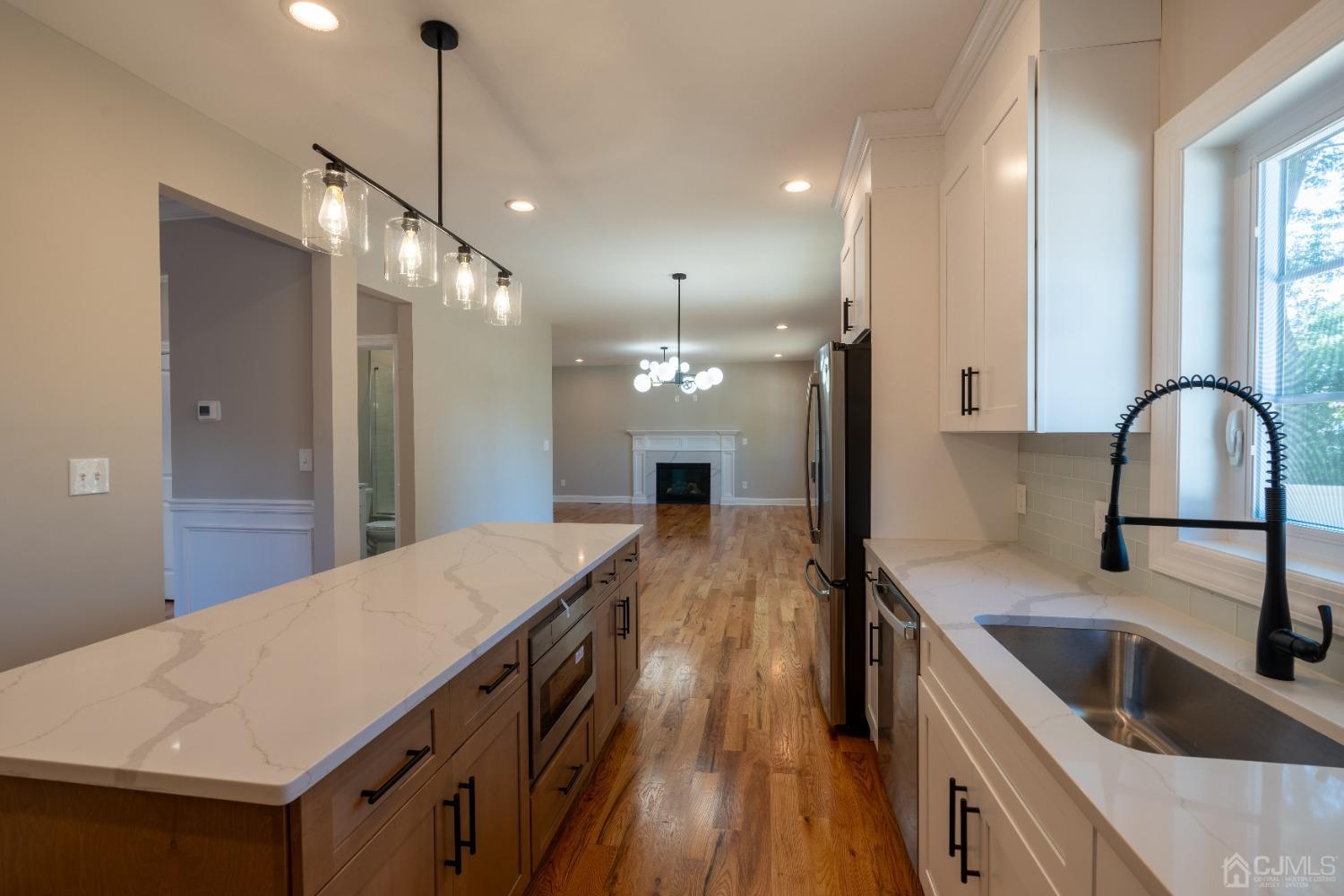624 New Dover Road Colonia, NJ 07067 - Photo 7 of 29 a kitchen with kitchen island a sink a counter top space stainless steel appliances and a window