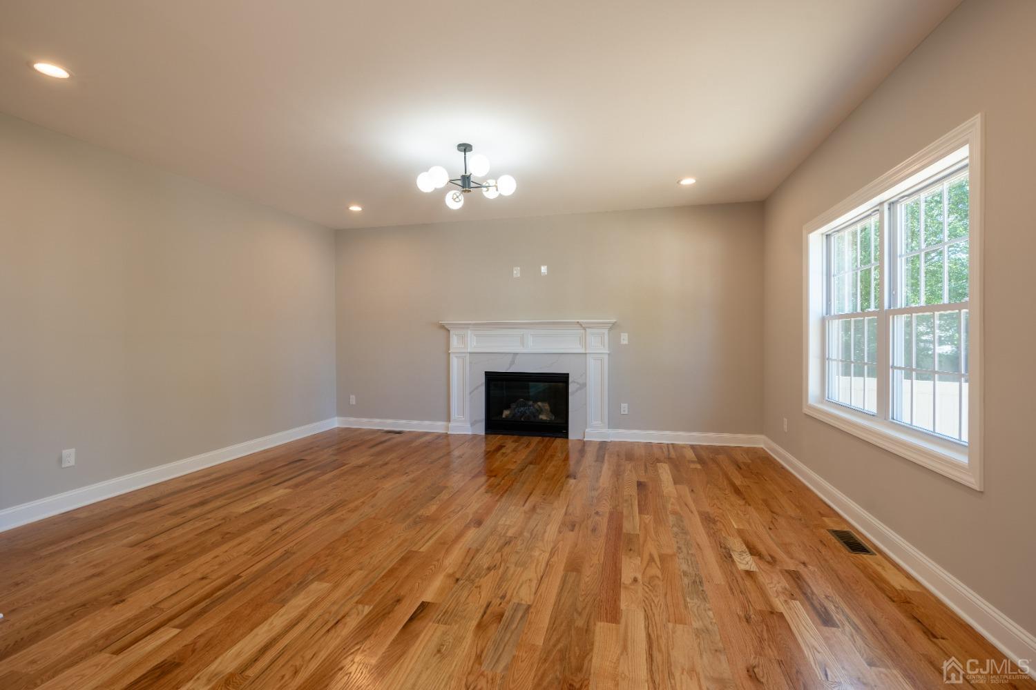 624 New Dover Road Colonia, NJ 07067 - Photo 10 of 29 wooden floor fireplace and windows in an empty room