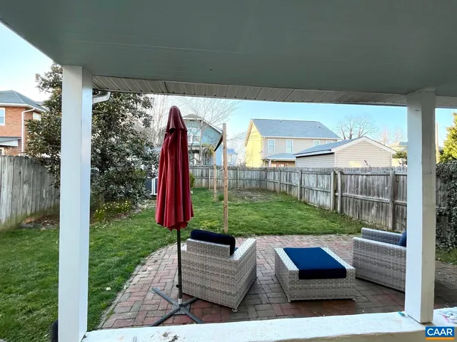 a view of a backyard with couches plants and wooden fence