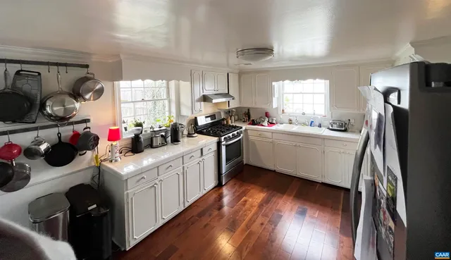 a kitchen with sink a refrigerator and wooden cabinets