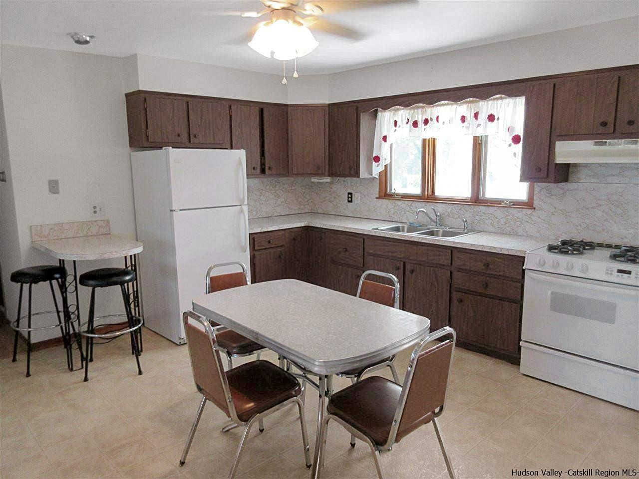15 Old Lasher Road Saugerties, NY 12477 - Photo 3 of 18 a kitchen with a table chairs sink and refrigerator