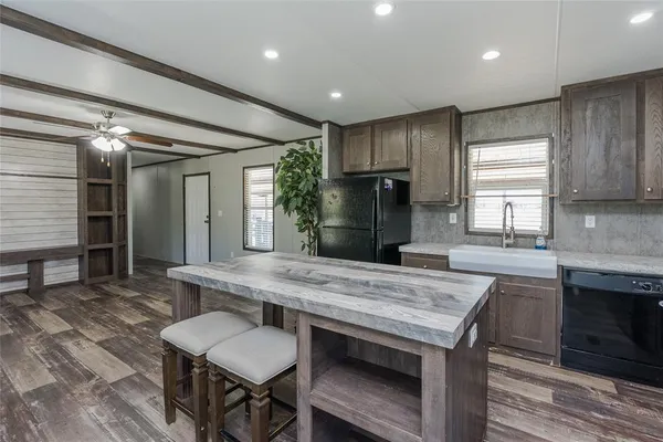 a kitchen with stainless steel appliances granite countertop a table chairs sink refrigerator and cabinets