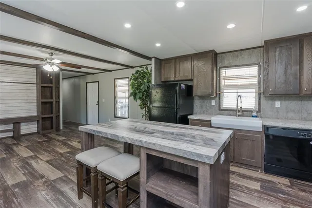 a kitchen with stainless steel appliances granite countertop a table chairs sink refrigerator and cabinets