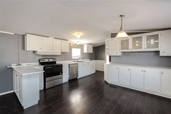 a kitchen with granite countertop a stove and a wooden floors