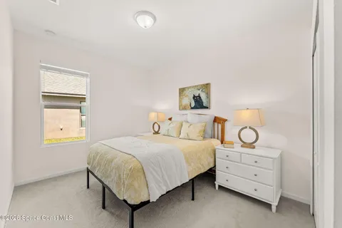 a bedroom with a bed and a large window