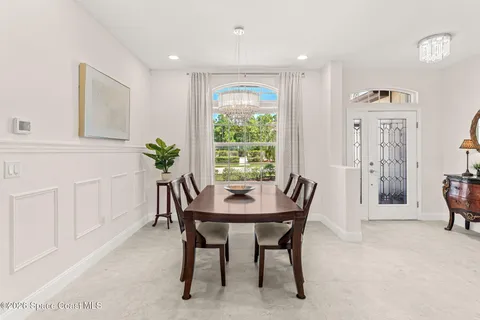 a living room with furniture a large window and a dining table