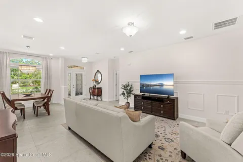 a living room with furniture flat screen tv and a large window