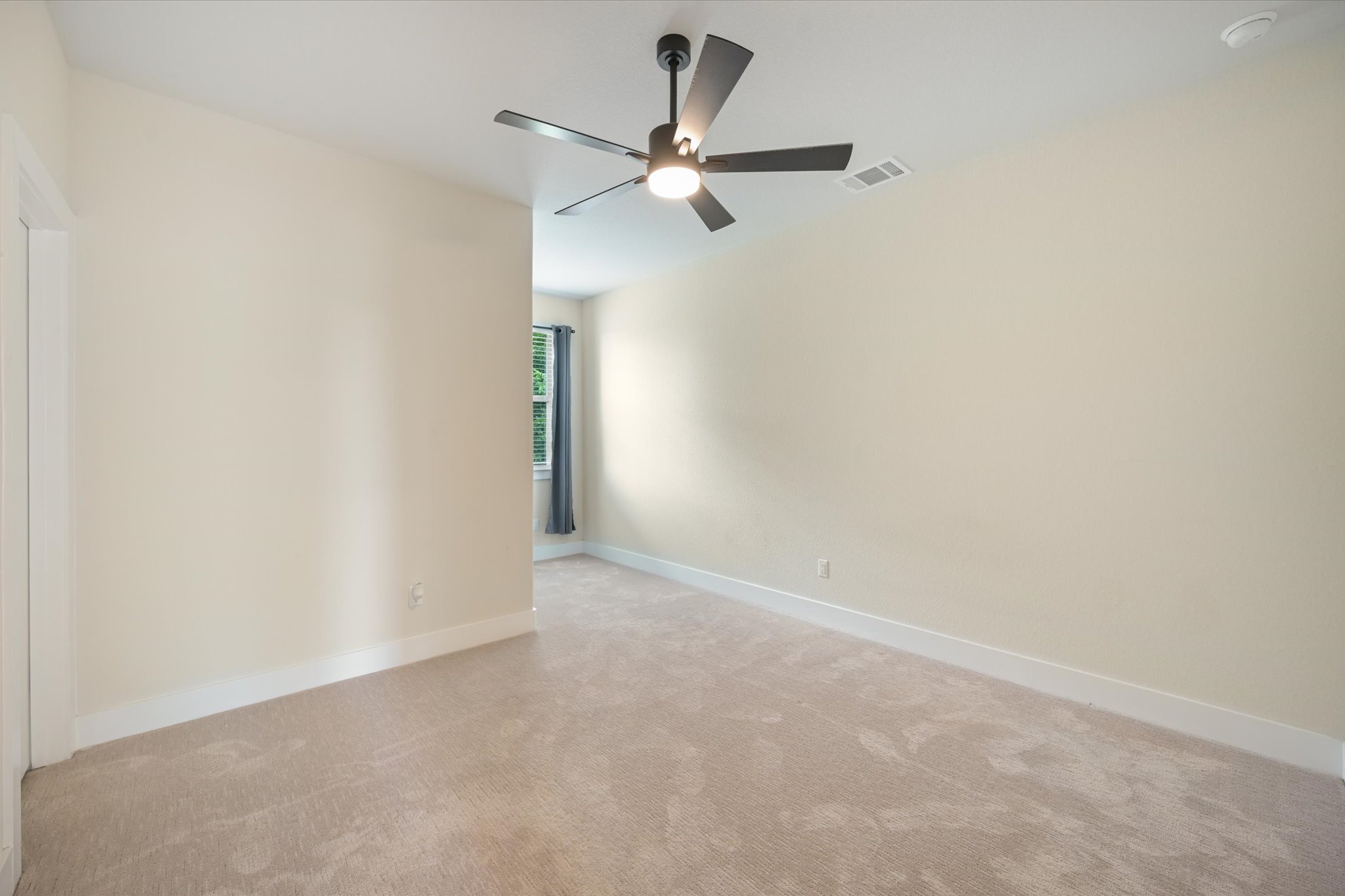 913 Presa Arriba Road Austin, TX 78733 - Photo 20 of 30 A quiet retreat with plush carpeting and a modern ceiling fan, offering a serene atmosphere.