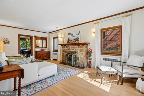 a living room with furniture a fireplace and a large mirror next to a window
