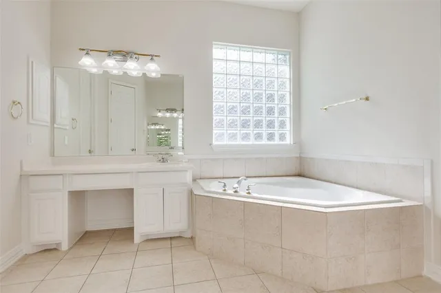 a bathroom with a bathtub a sink a vanity and a window
