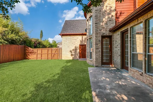 a view of a house with a small yard and wooden fence