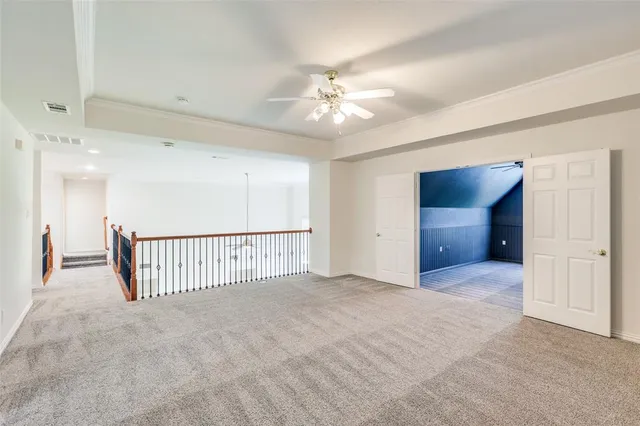a view of a livingroom with a ceiling fan & windows