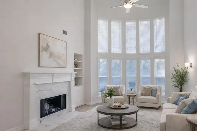 a living room with furniture a fireplace and a large window
