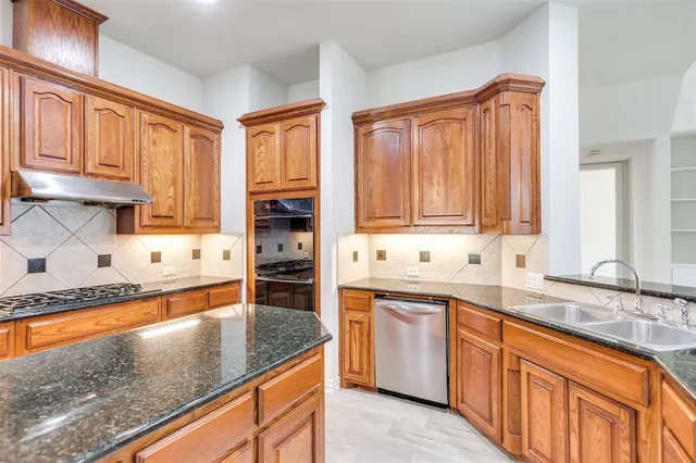 a kitchen with stainless steel appliances granite countertop a sink stove and cabinets