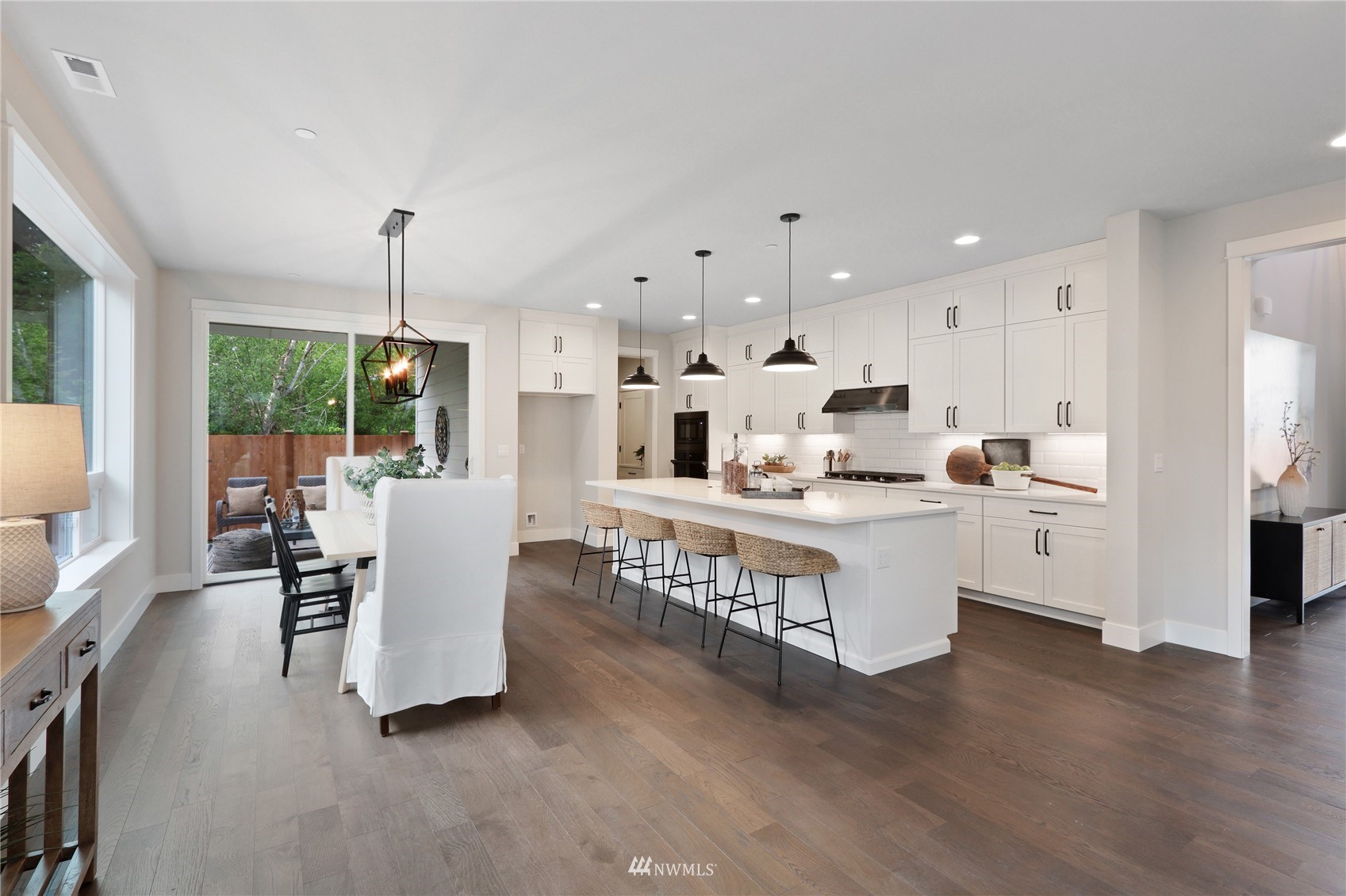 1228 197th Place Southeast Bothell, WA 98012 - Photo 7 of 34 a kitchen with stainless steel appliances kitchen island granite countertop a table chairs and a refrigerator