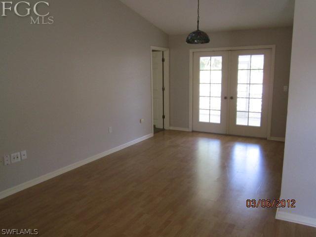 17533 Ingram Road Fort Myers, FL 33967 - Photo 3 of 9 an empty room with wooden floor and windows