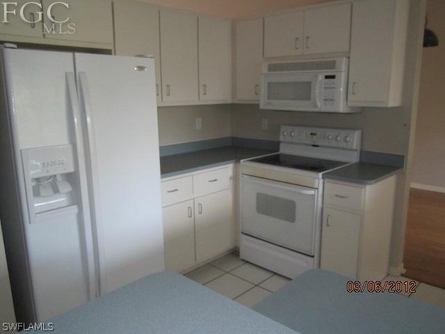 17533 Ingram Road Fort Myers, FL 33967 - Photo 5 of 9 a kitchen with white cabinets and white appliances