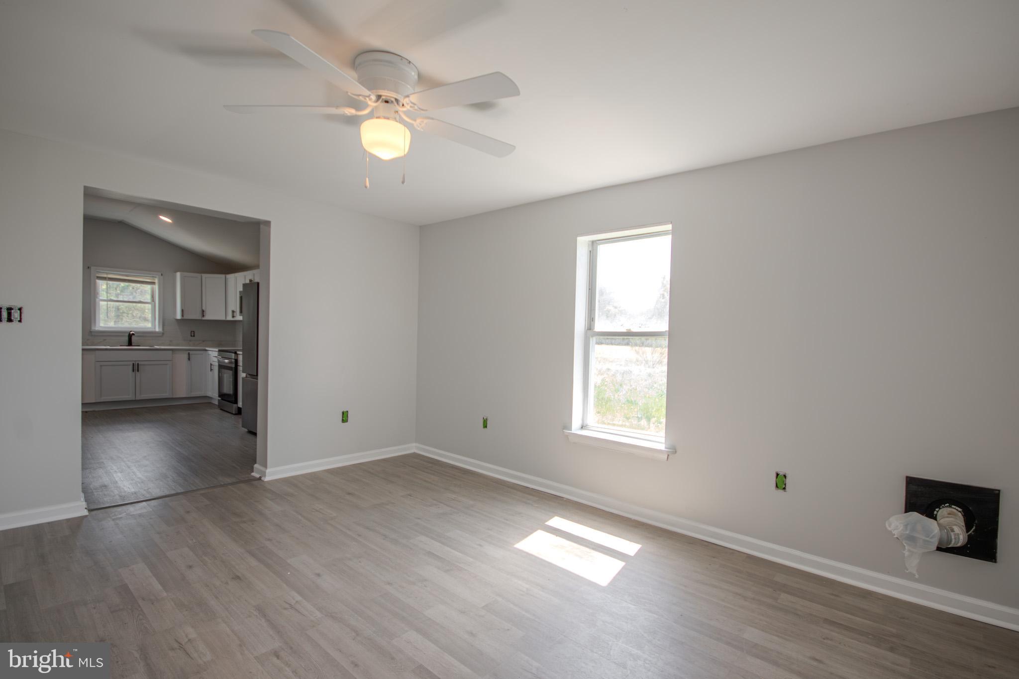 5693 Landon Store Road Marion Station, MD 21838 - Photo 4 of 20 an empty room with wooden floor and windows