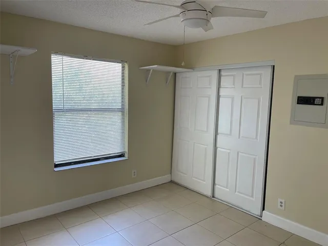an empty room with a window and a fan