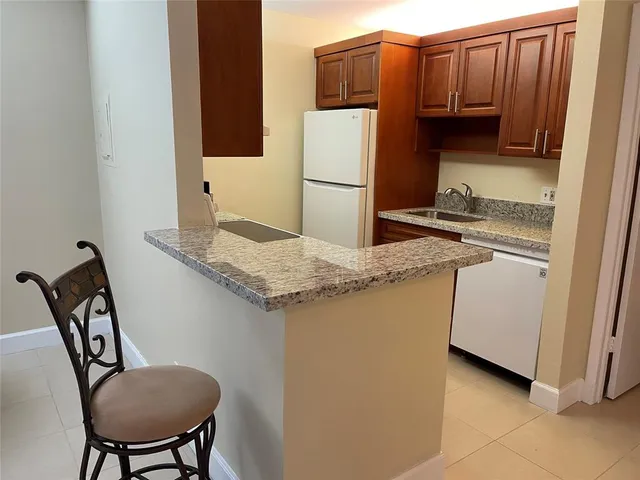 a kitchen with stainless steel appliances granite countertop a refrigerator a stove a sink and a microwave