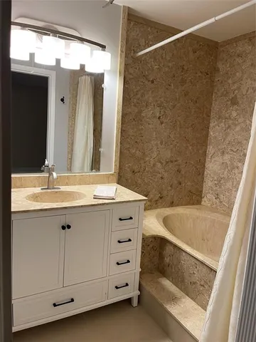 a bathroom with a double vanity sink a mirror and a bathtub