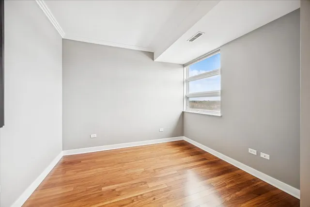 a view of empty room with wooden floor