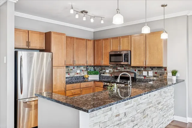 a kitchen with kitchen island granite countertop a sink stainless steel appliances and cabinets