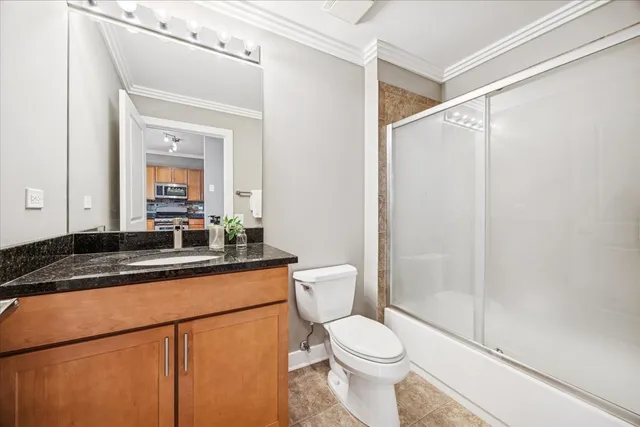 a bathroom with a granite countertop sink mirror vanity and toilet