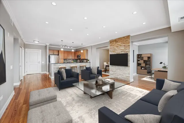 a living room with furniture kitchen view and a flat screen tv