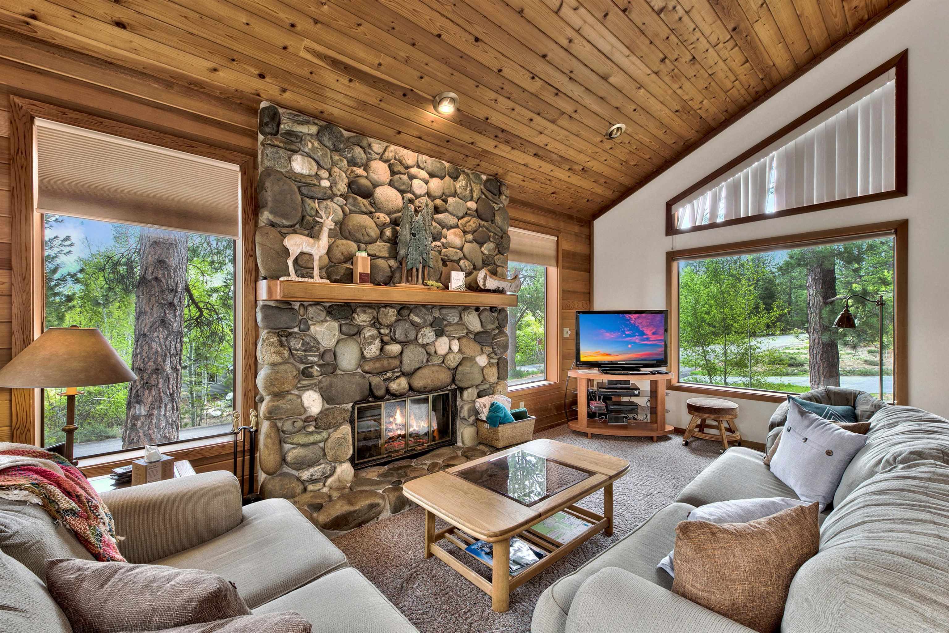 253 Basque Drive, Unit SHARE #2 Truckee, CA 96161 - Photo 2 of 24 a living room with furniture a fireplace and a floor to ceiling window