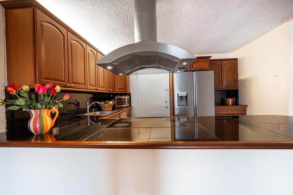 22605 Southwest 66th Avenue, Unit 102 Boca Raton, FL 33428 - Photo 2 of 27 a kitchen with a refrigerator and a potted plant