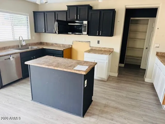 a kitchen with stainless steel appliances kitchen island wooden cabinets and sink