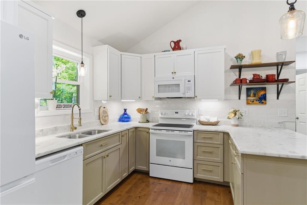 191 Oakwood Road Blairsville, GA 30512 - Photo 13 of 43 a kitchen with kitchen island white cabinets and white appliances