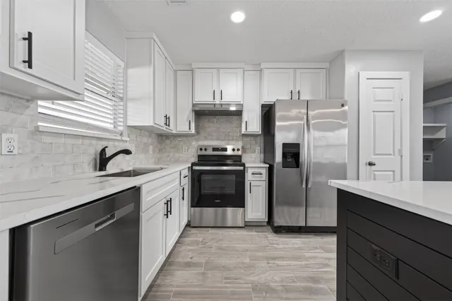 a kitchen with stainless steel appliances granite countertop a sink stove and refrigerator