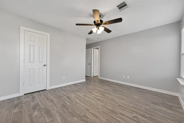 a view of an empty room with wooden floor