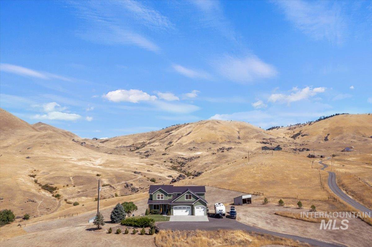 11660 Timber Butte Road Sweet, ID 83670 - Photo 2 of 49 Two-story residence featuring a two-car garage, expansive paved driveway, and mature landscaping