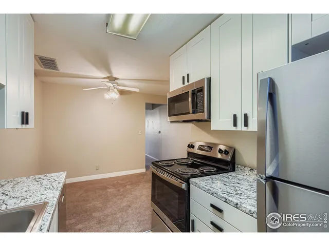 a kitchen with granite countertop a refrigerator stove and microwave