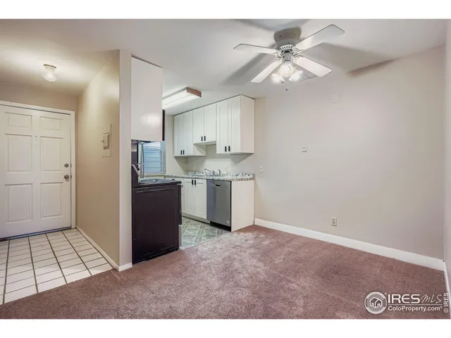 a open kitchen with cabinets appliances and a ceiling fan