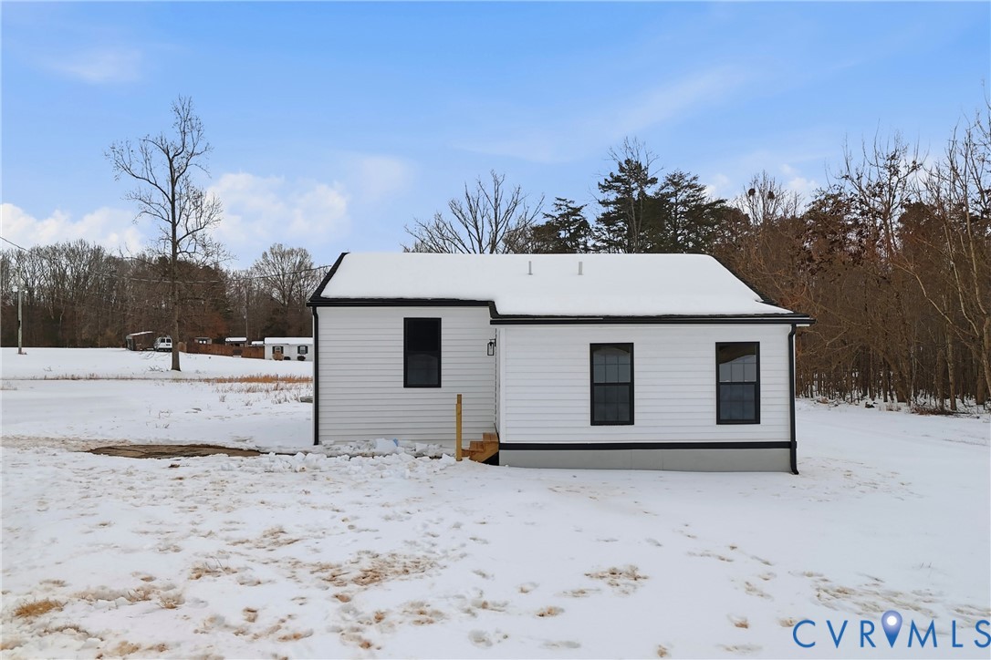 7625 Venable Road Kents Store, VA 23084 - Photo 26 of 31 a view of a white house with a yard covered in snow