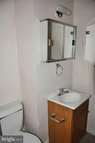 a bathroom with a sink mirror vanity and toilet