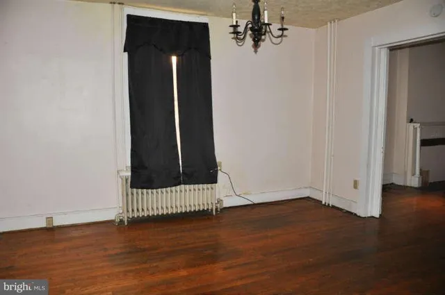 an empty room with wooden floor and a window