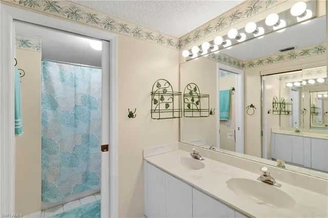 a bathroom with a double vanity sink mirror and shower