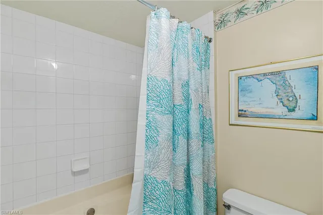 a bathroom with a shower curtain and a toilet