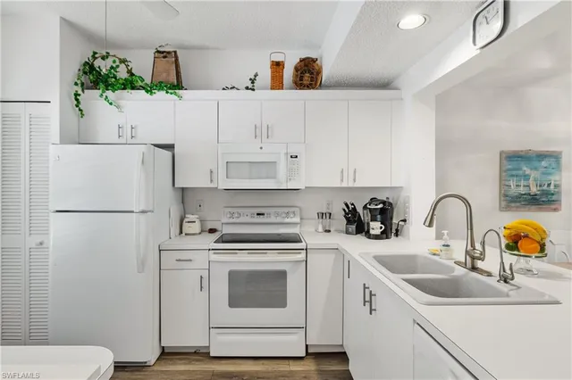 a kitchen with white cabinets and white appliances